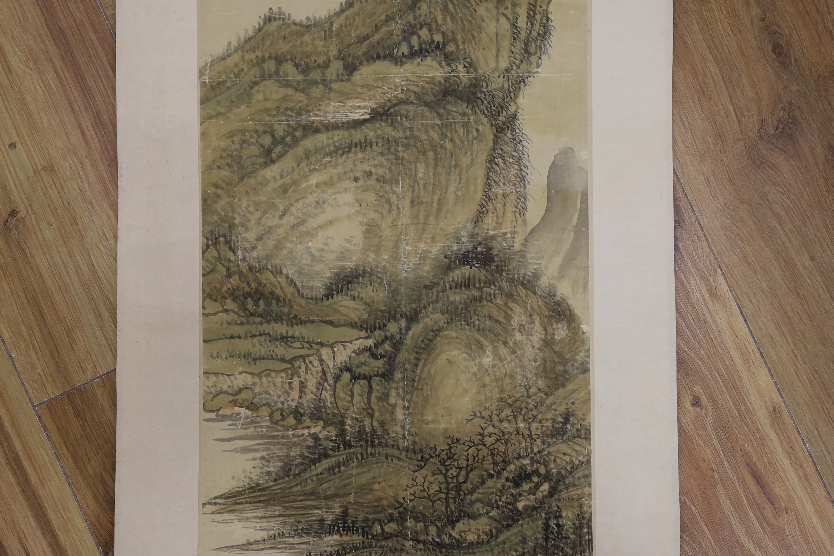 A Chinese landscape scroll painting on silk, Qing dynasty inscribed and signed, artist’s seal and collector’s seal lower left, image 139cm x 27.5cm, remounted